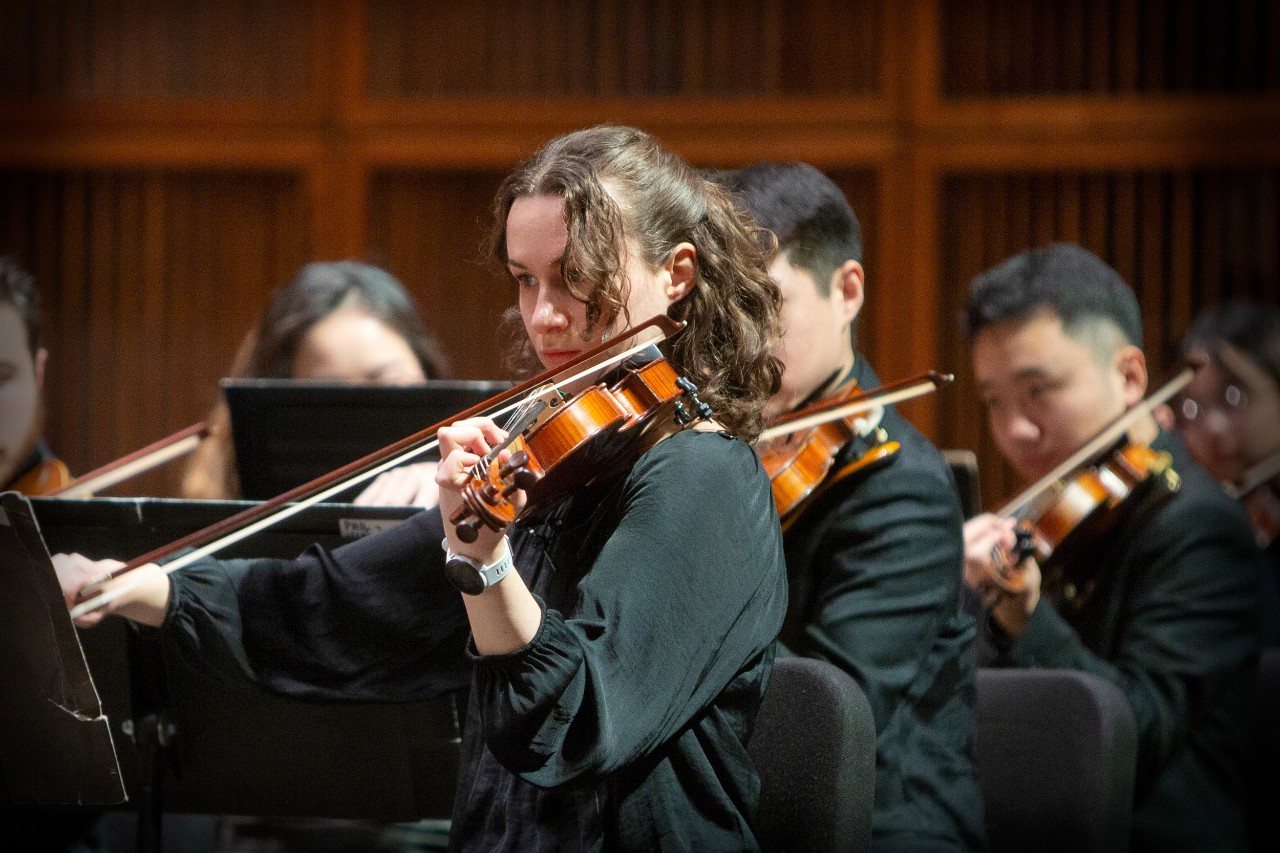 CCM Philharmonia violin students perform on the Corbett Auditorium stage.