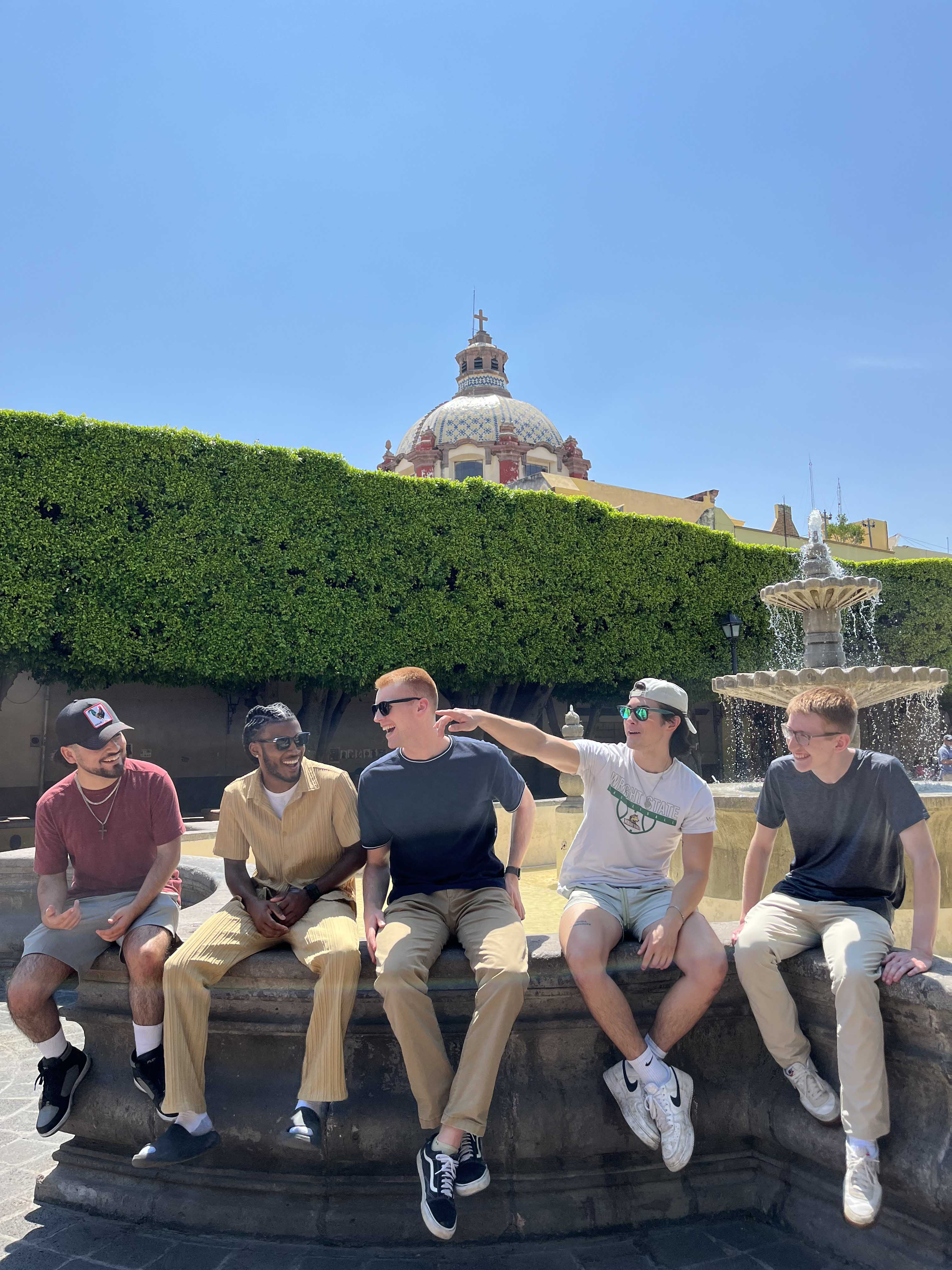 HHS students seated on a stone wall
