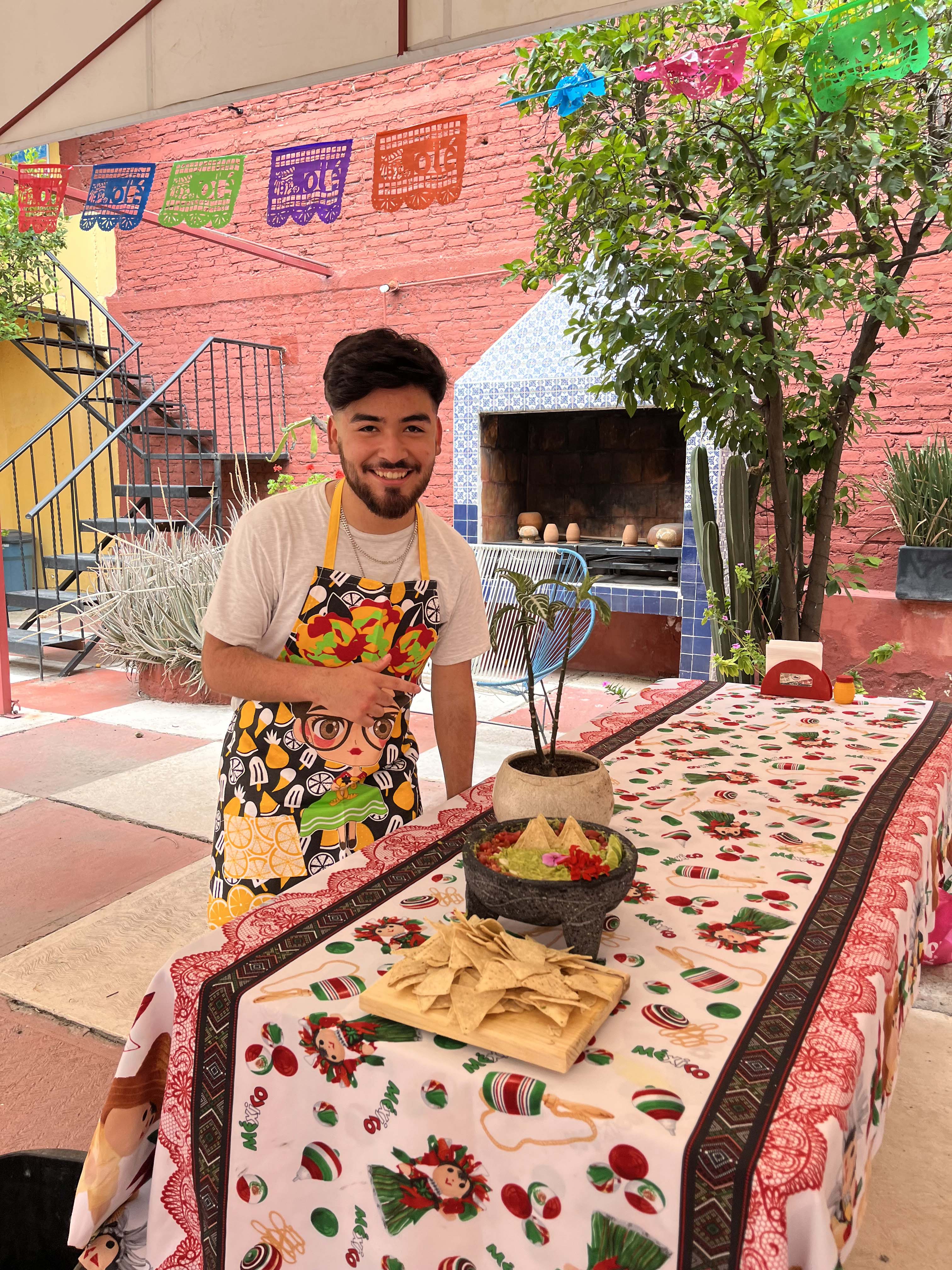 HHS student wearing an apron and smiling in front of a meal