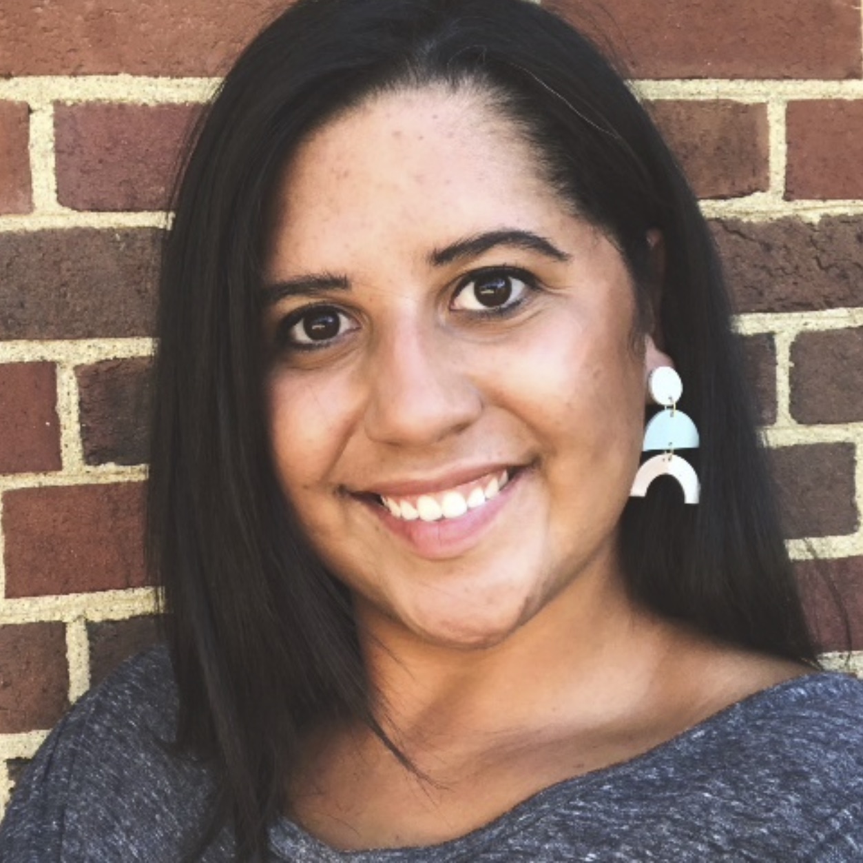 Headshot of a woman against a brick wall