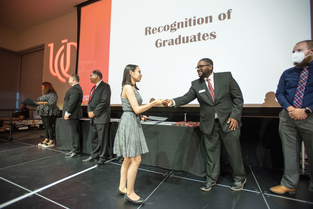 Student shaking hands with someone on the stage at the Honors Graduation