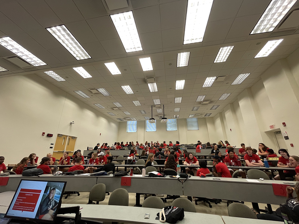 A group of UHP students at the welcome event in a large classroom