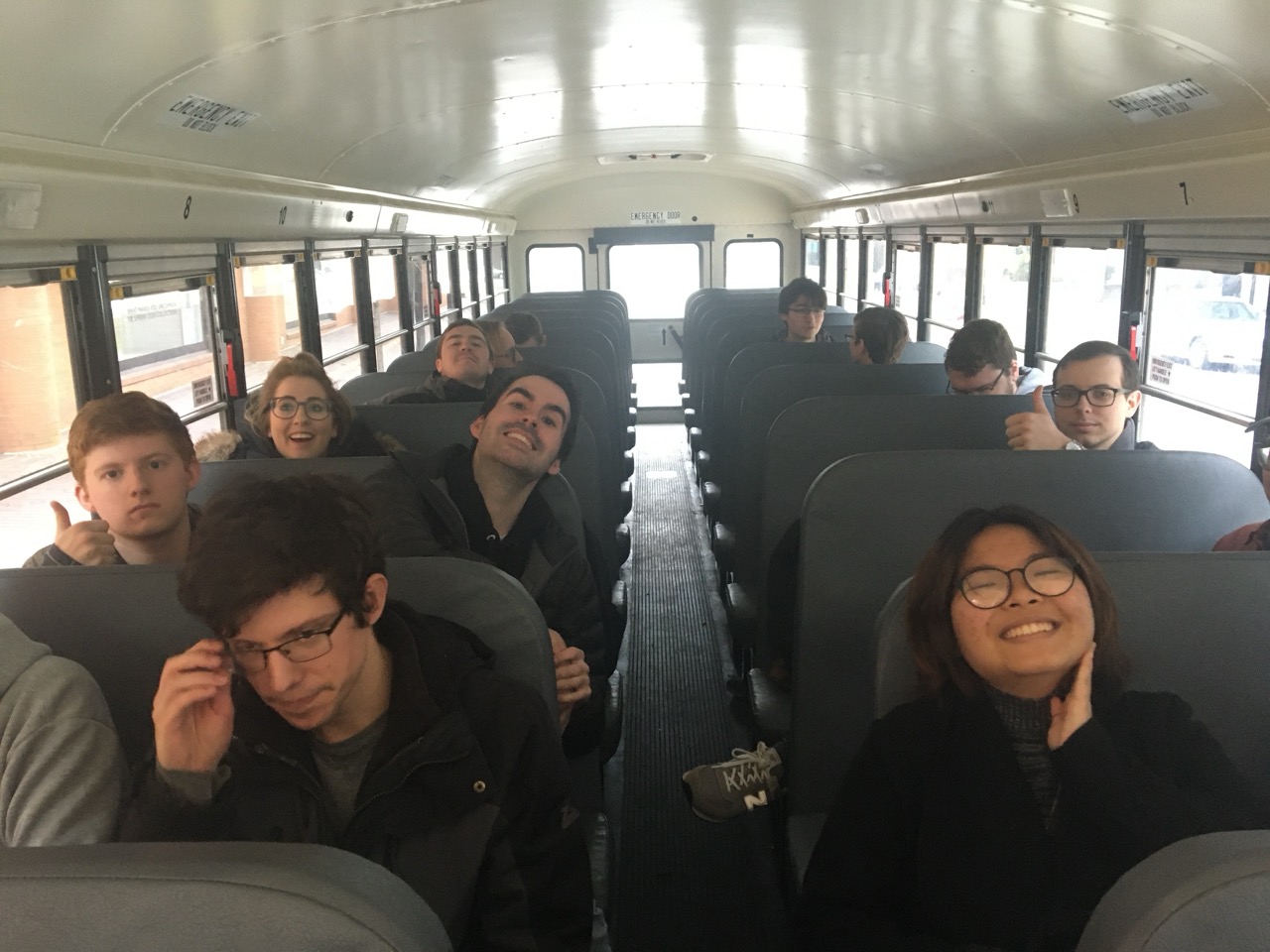 Students on a bus smiling at the camera