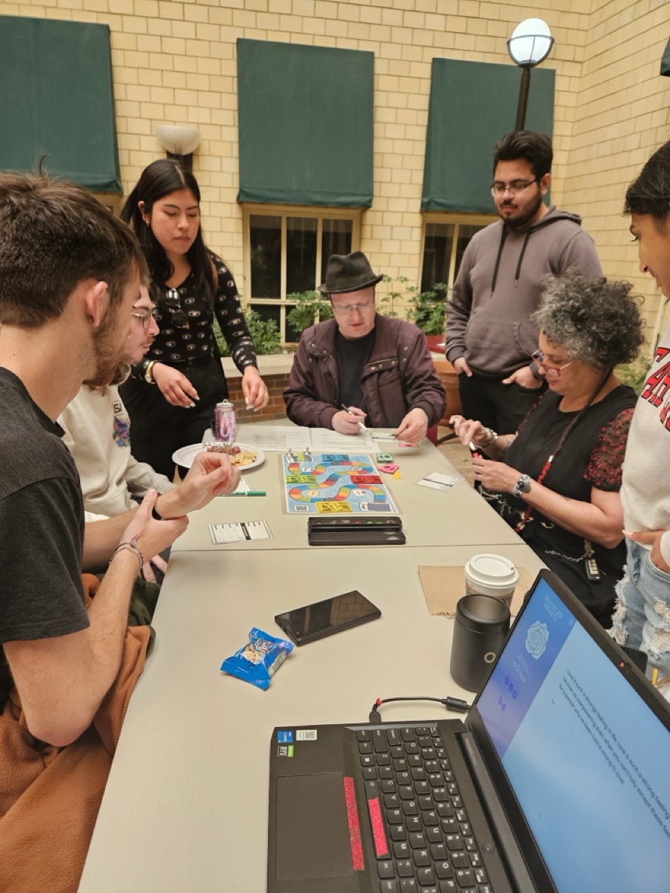 Students sitting around the table with an instructor playing a board game