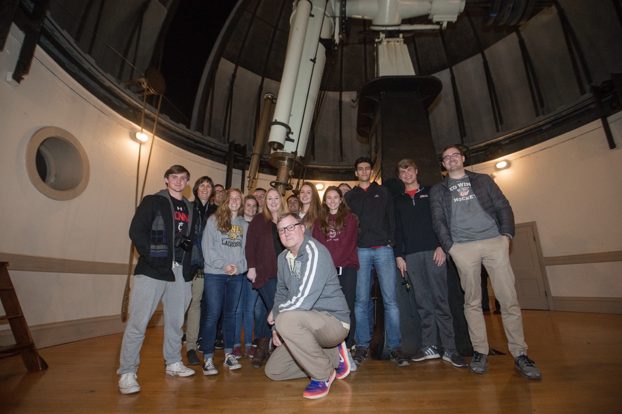 Students posing in front of a giant telescope