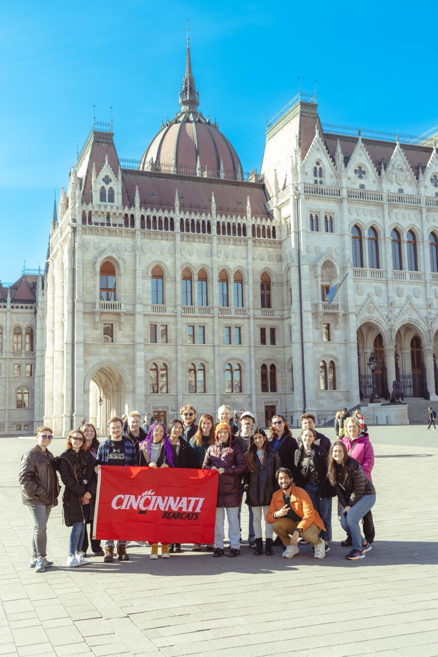 Students in Austria holding up a UC flag