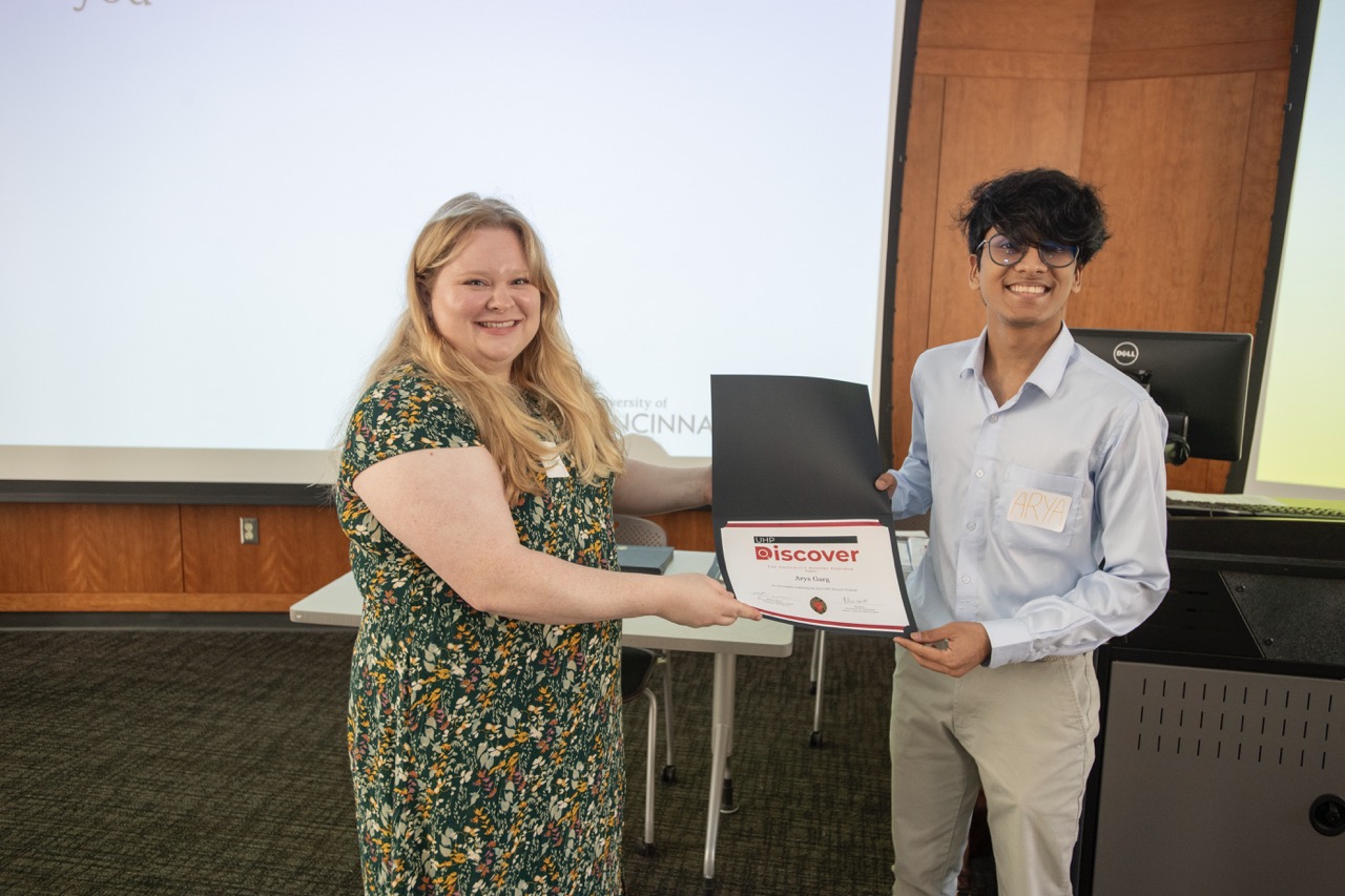 Student with their advisor holding a certficate of completion