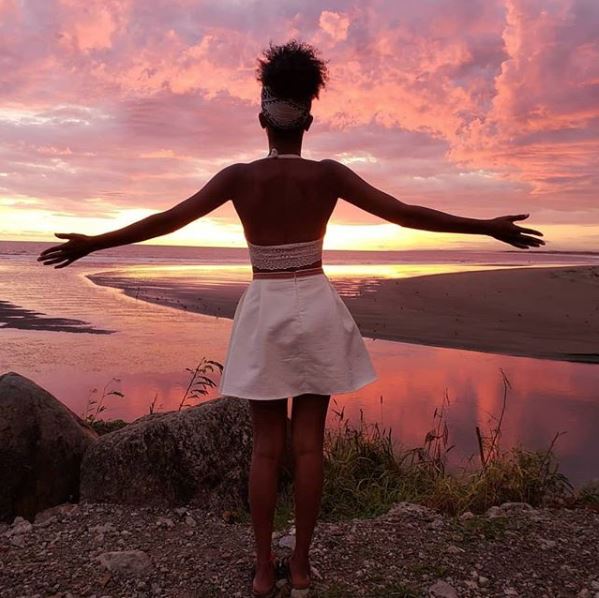 A study abroad student looks out on a sunset
