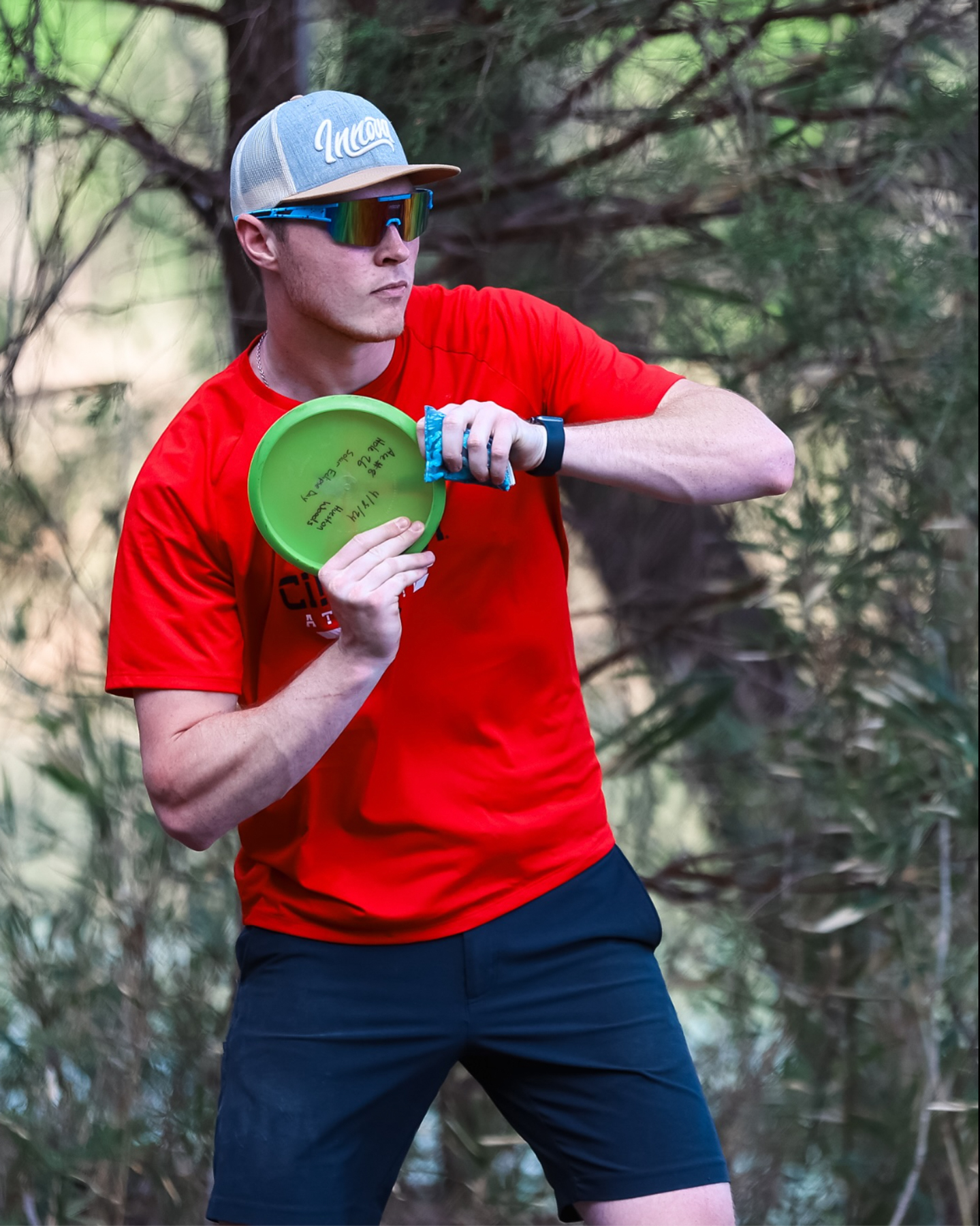 A player in a UC jersey lines up a shot with a disc.
