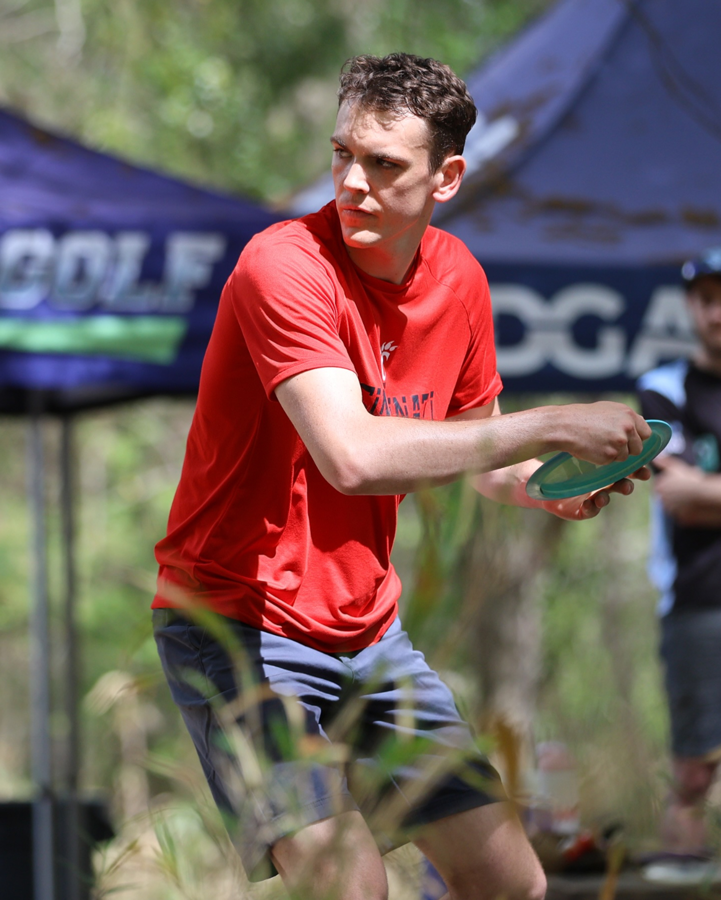 A player in a UC jersey prepares to throw a disc.