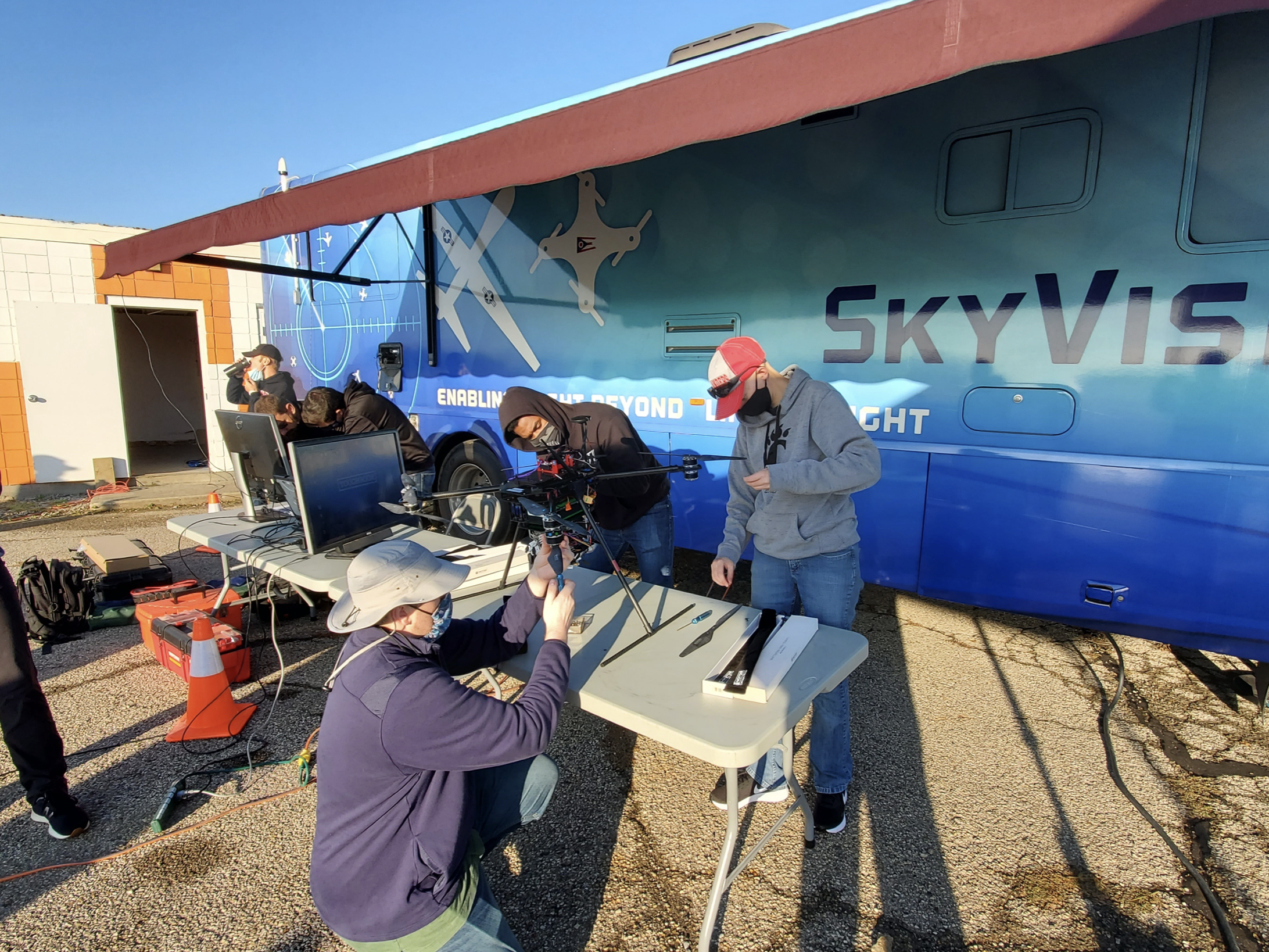Students work on drones at a table.