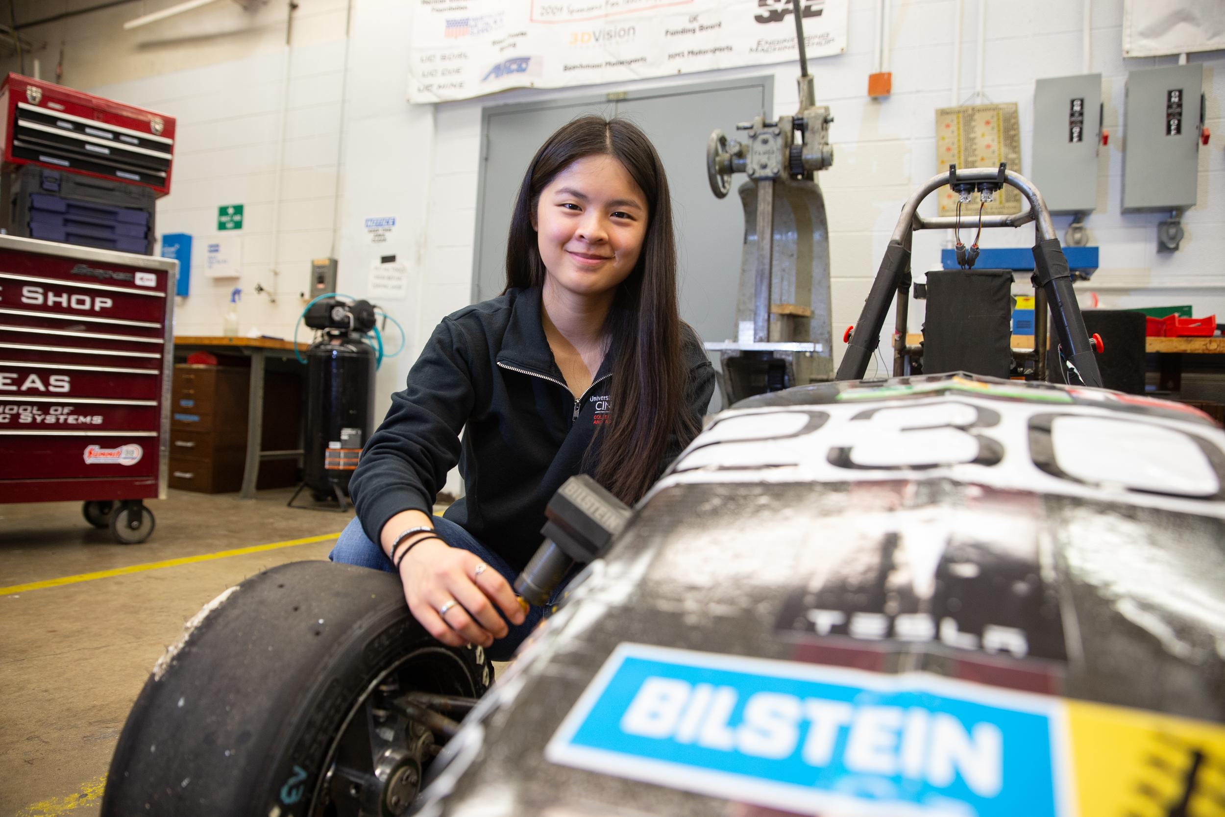 UC Student Emma Vail poses with a car at Honda Motor Co.