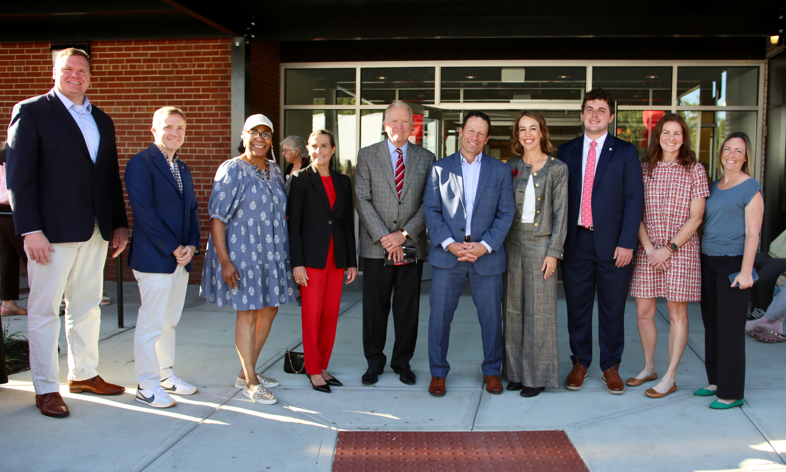 Several people stand in front of a new medical clinic.