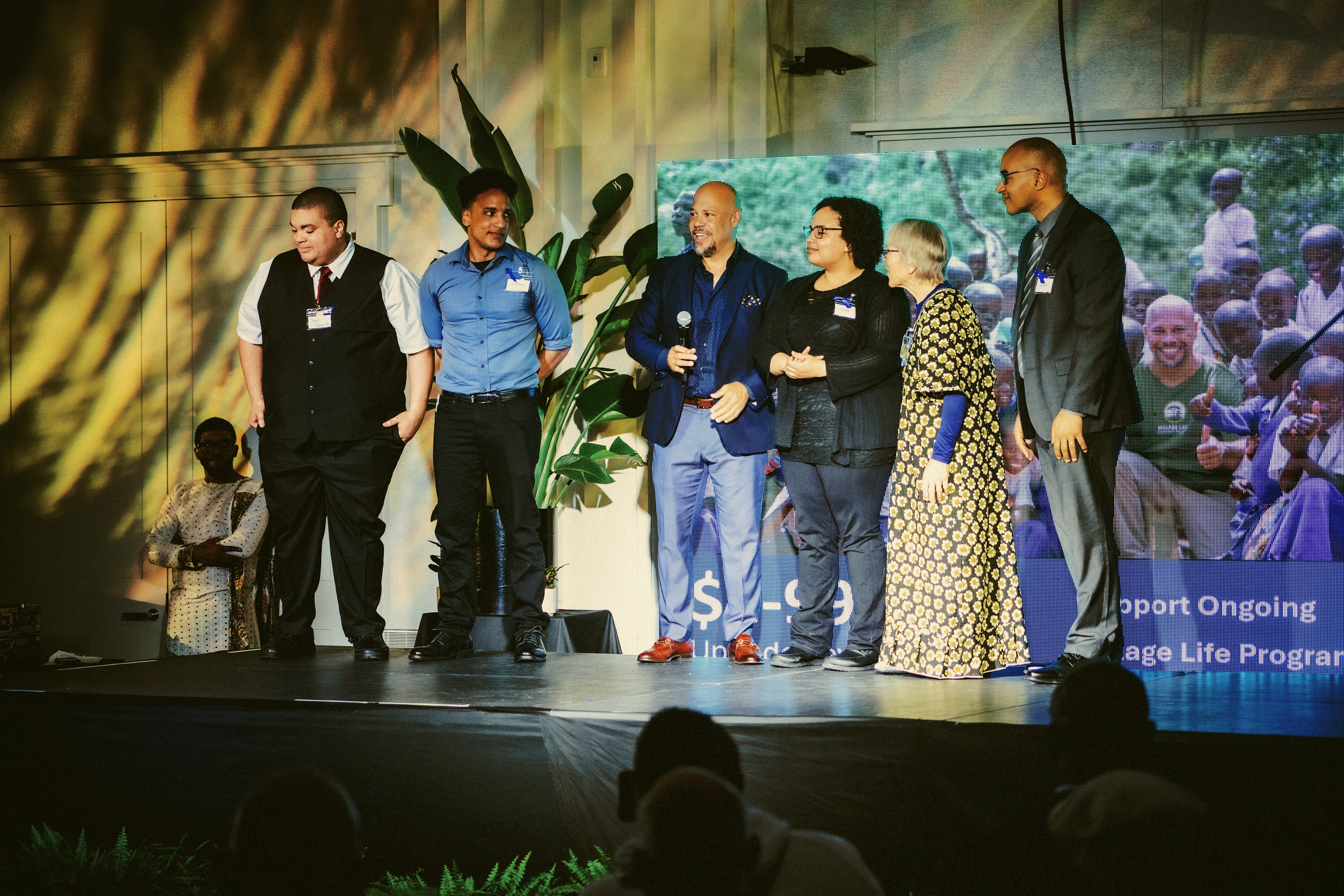 Village Life founder, Chris Lewis stands with Dr. Esther Kawira from Tanzania and her family.