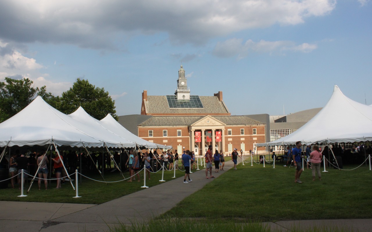 Promotional tables under tents set up on the campus lawn.
