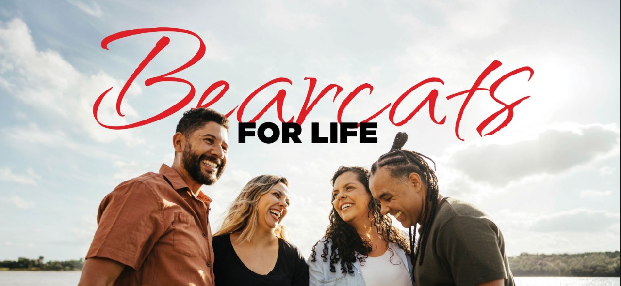 An example of the handwritten version of the word Bearcats used within the phrase "This is where Bearcats belong" depicted above four UC students