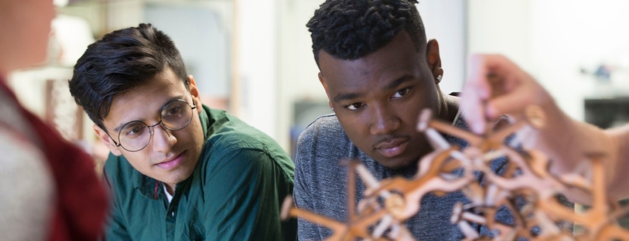 Students inspect a wooden model