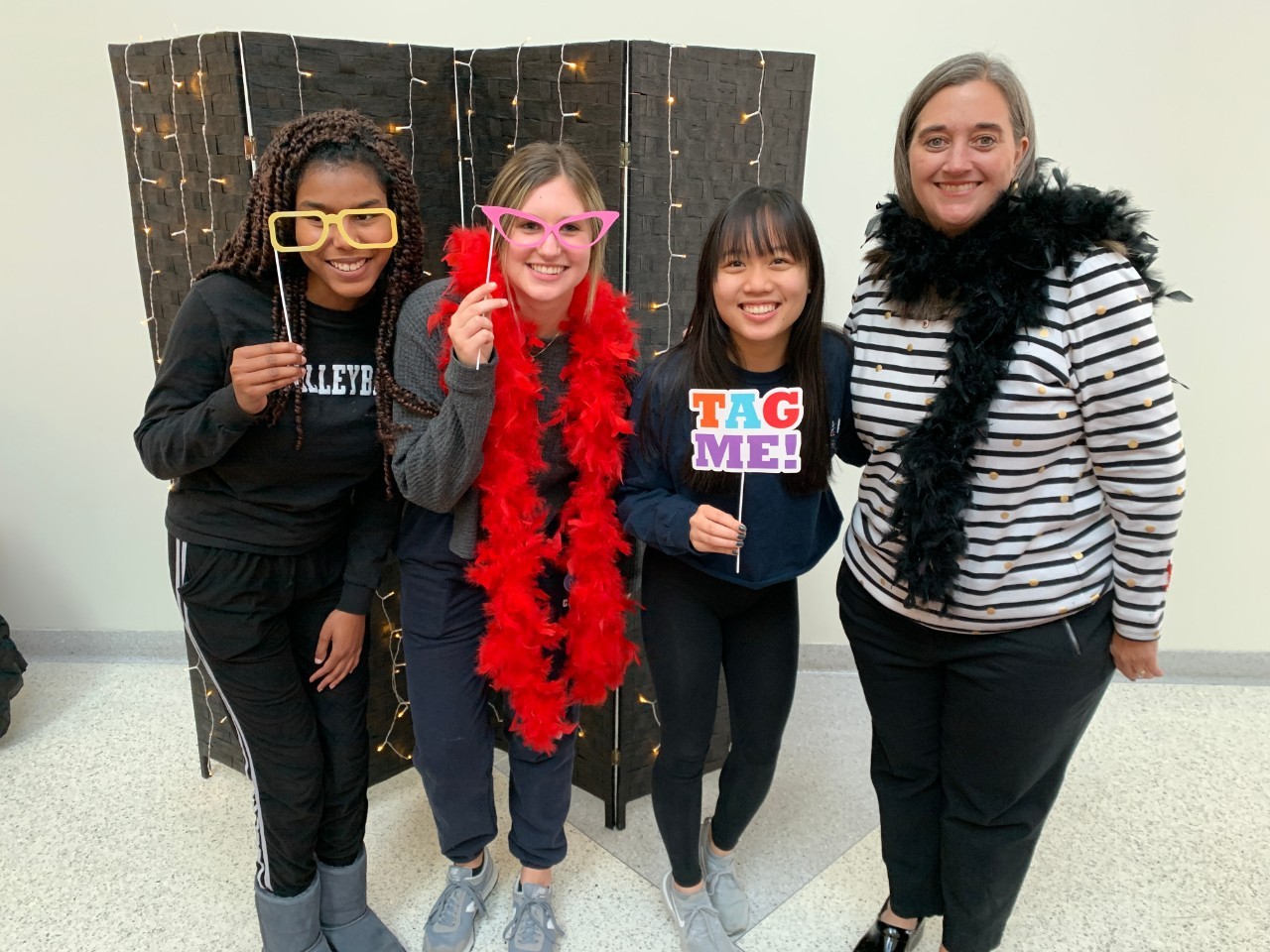 First Lady posing at photo booth with three students