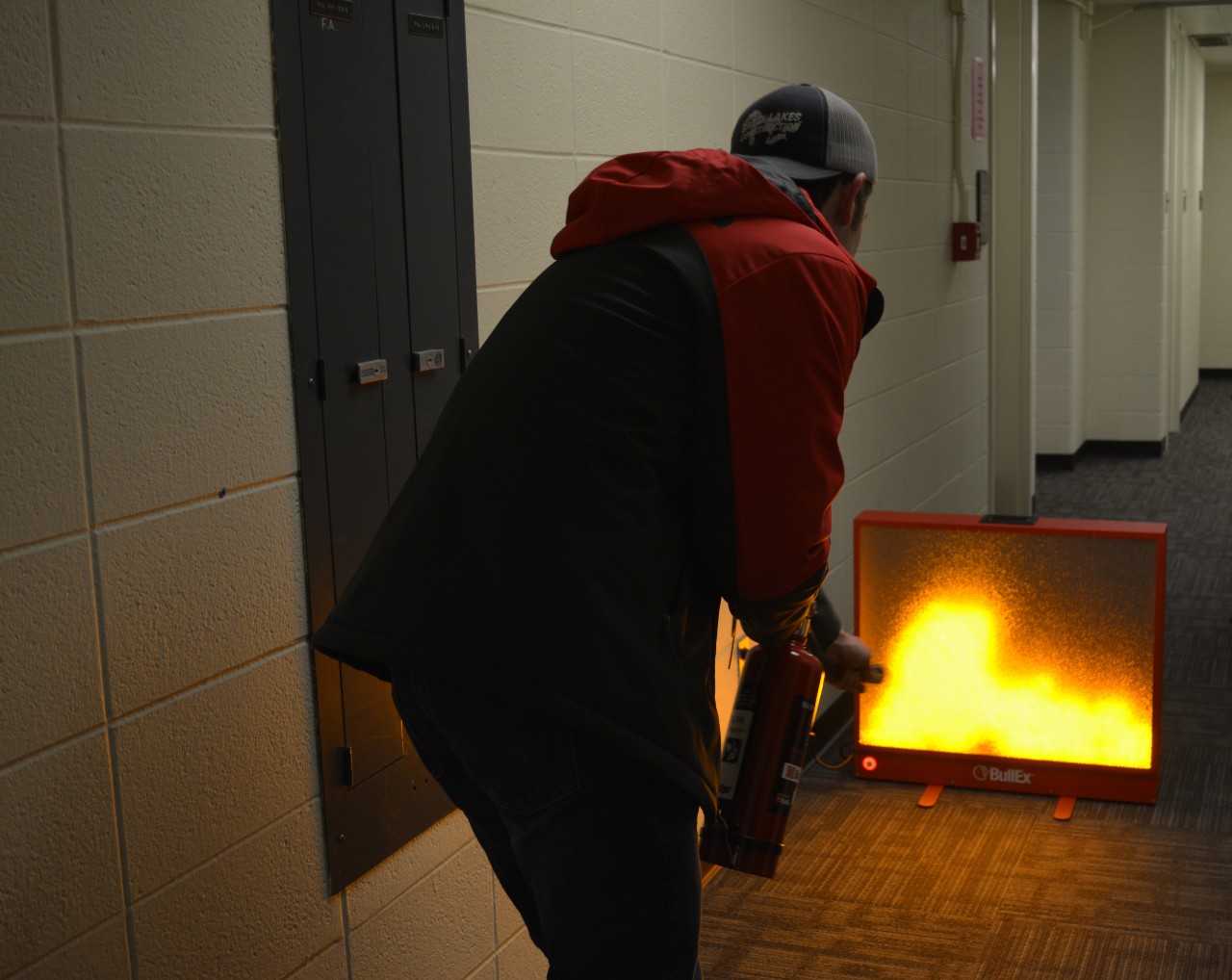 A student learns how to use a fire extinguisher.