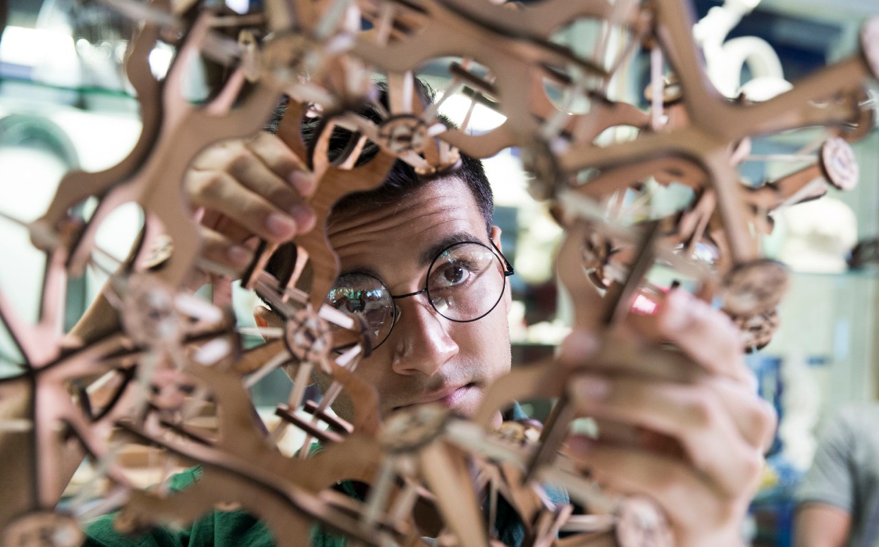 A student in glasses working on a rapid prototyping project in a lab.