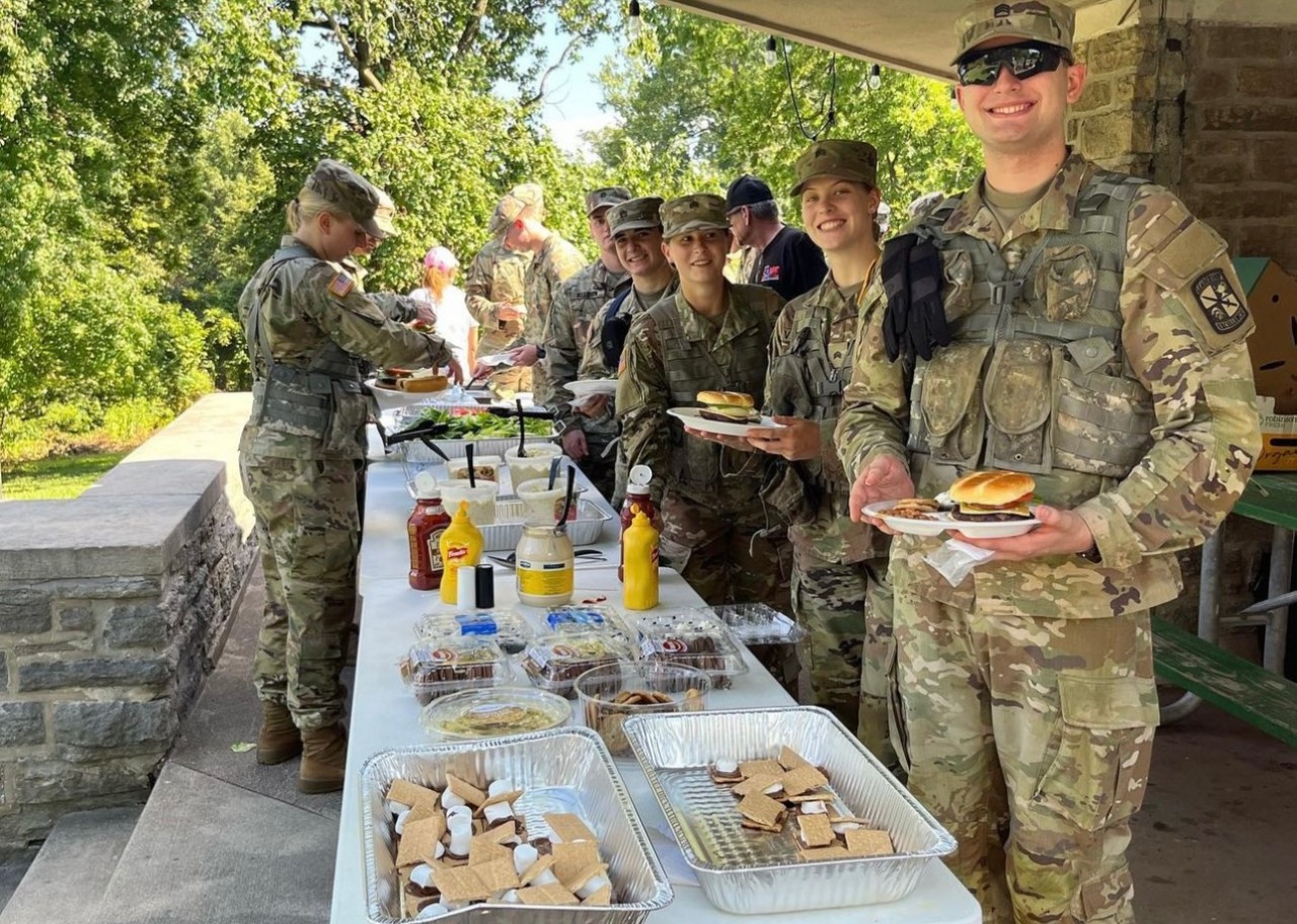 Several ROTC students making plates of food at a cookout. 