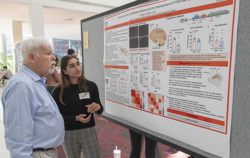 two people study a research poster