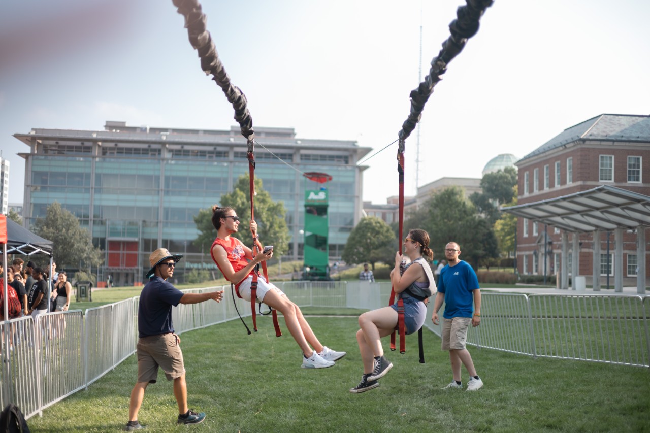 Students at a PAC event in fall 2023, "PAC Welcomes You Back", riding a zipline