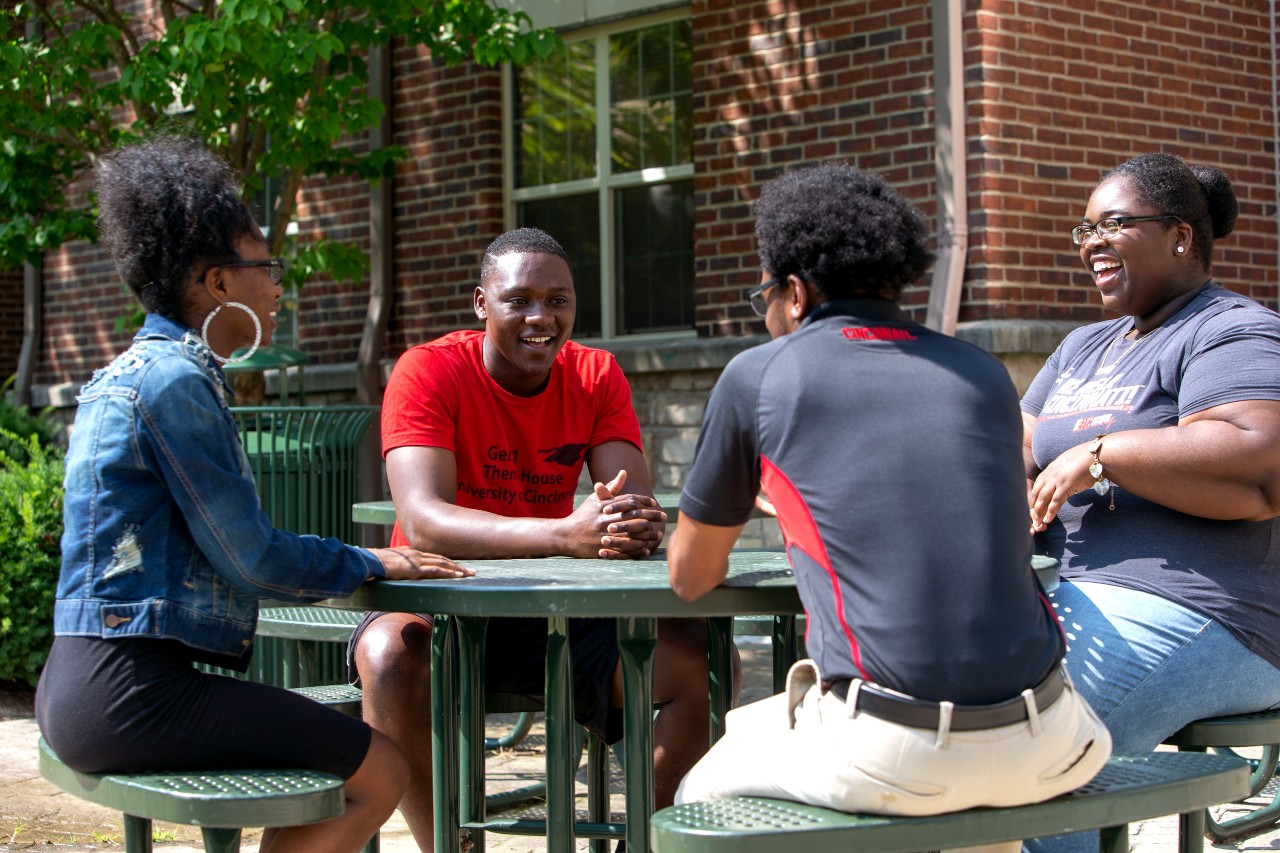 Students sitting together at picnic table outside