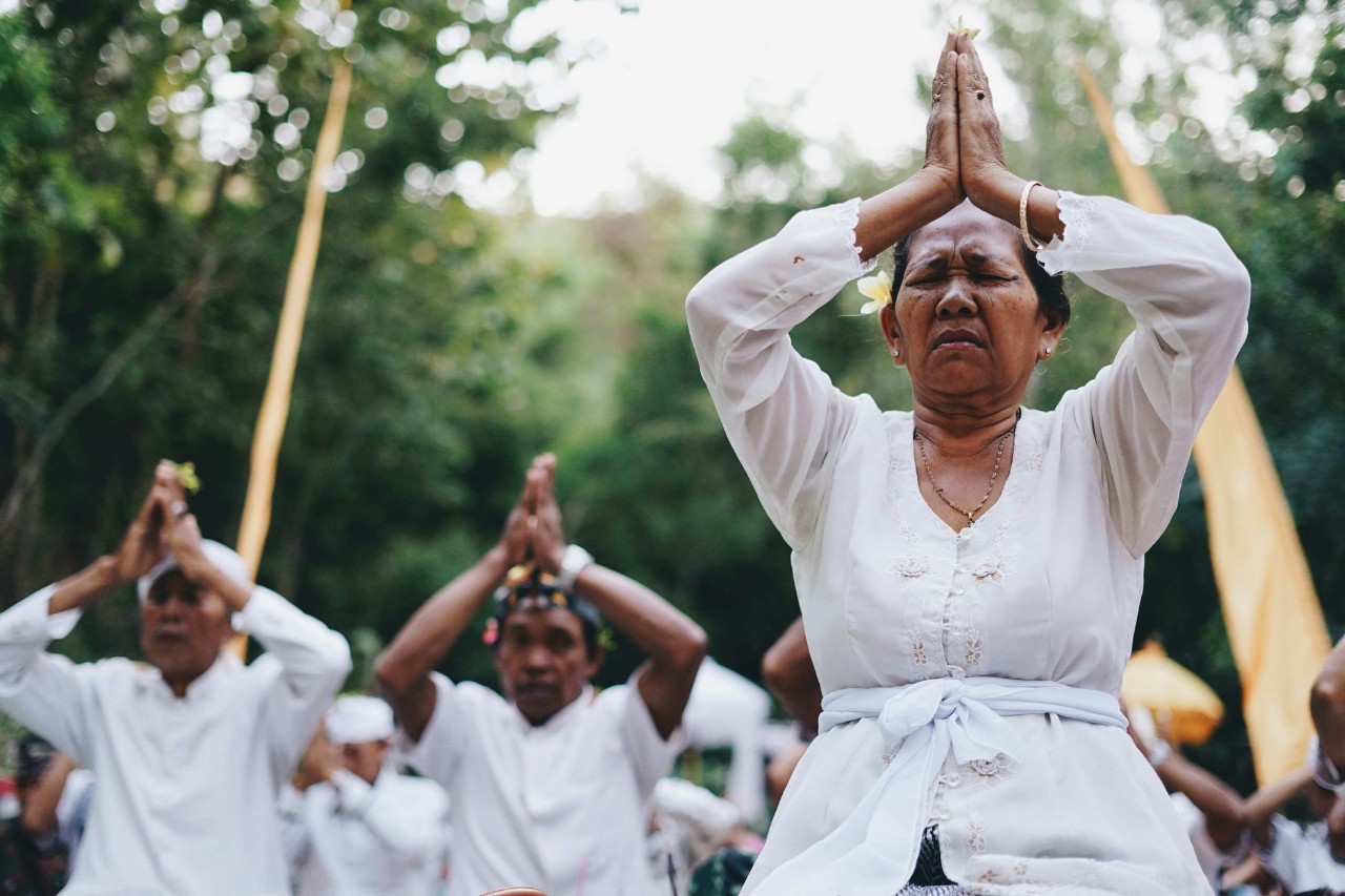 People dressed in white kneeling in prayer