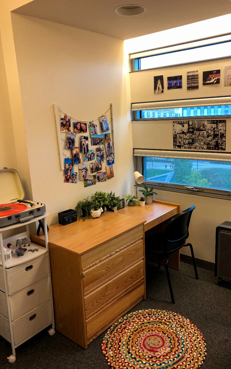 Desk with photos hanging above and three narrow horizontal windows to the right.