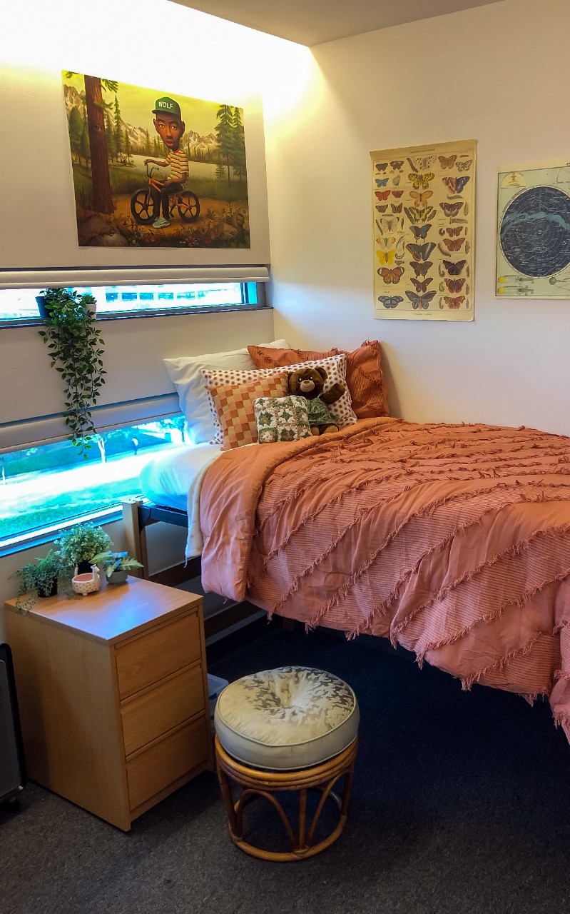 Twin bed along right of room with nightstand and windows near the head of the bed.