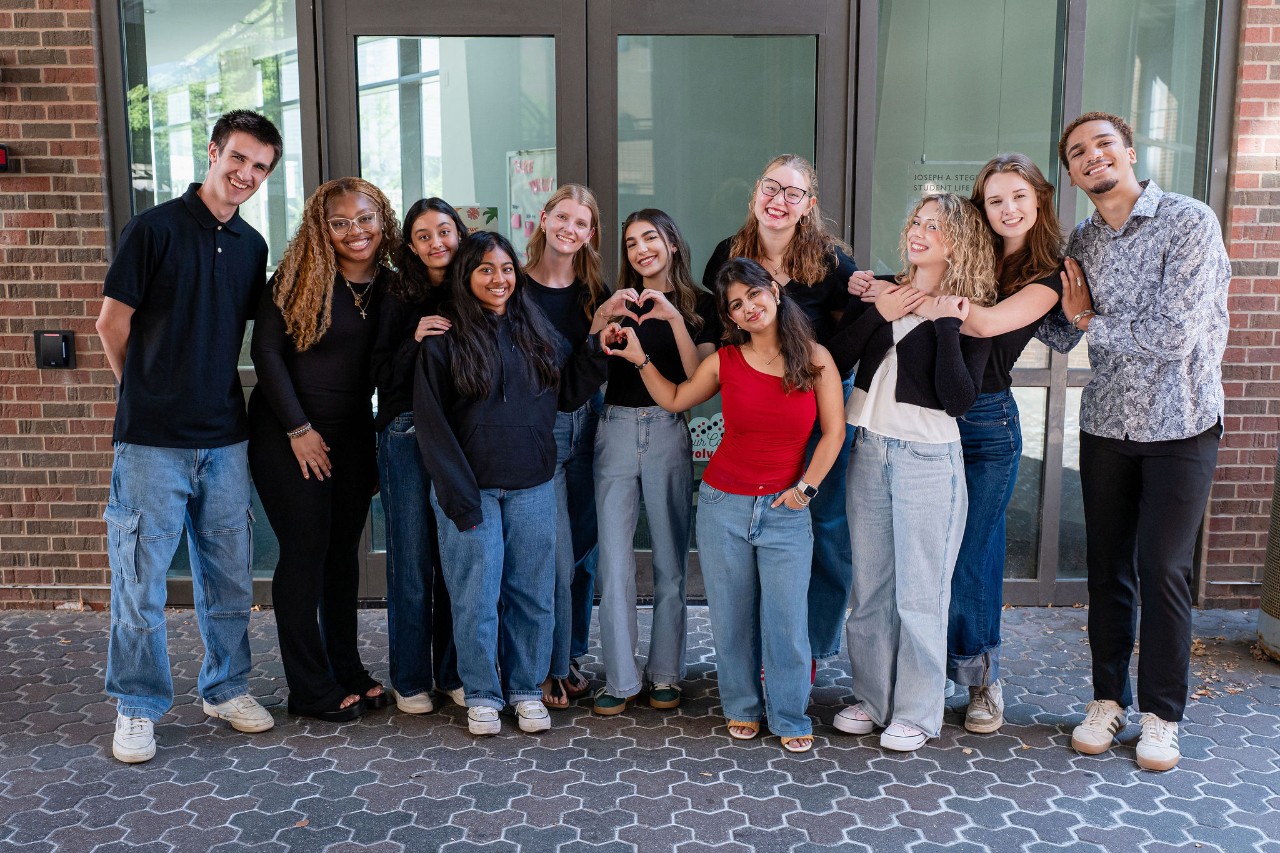 Group of students standing outside a building smiling at the camera