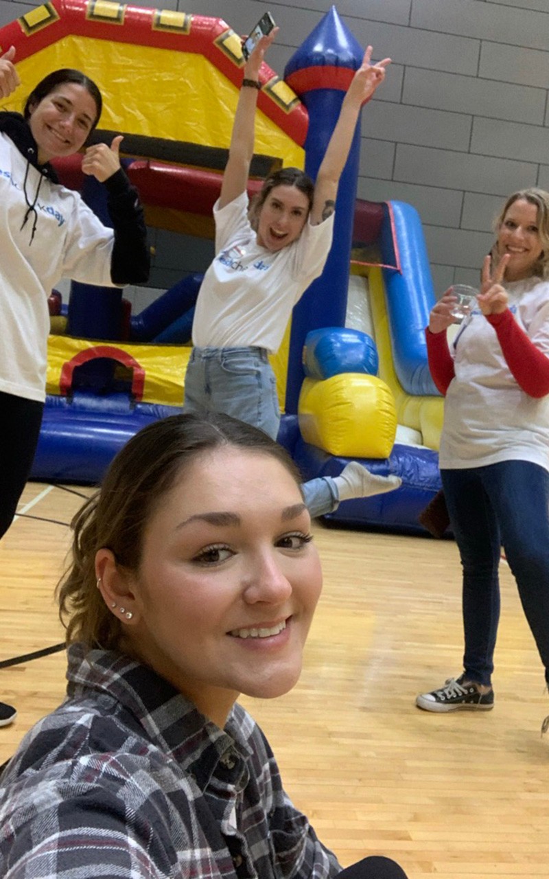 student in front of a bounce house at the campus recreation center on fresh check day