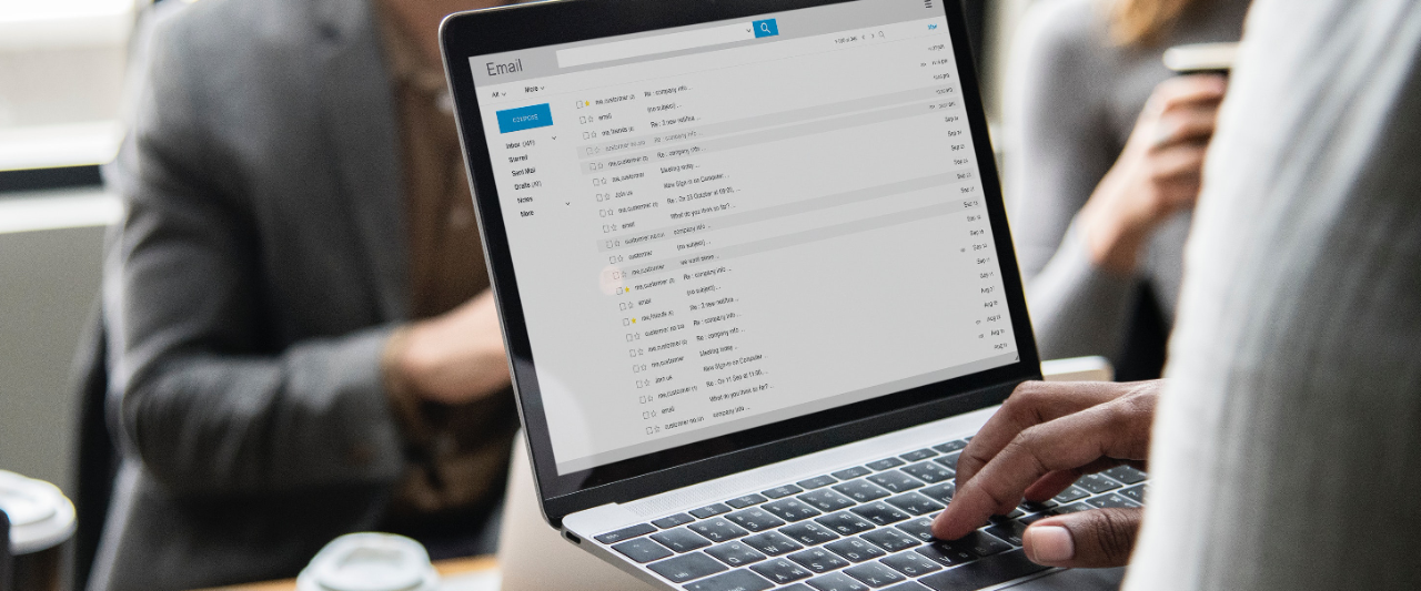 Hands accessing email on a laptop