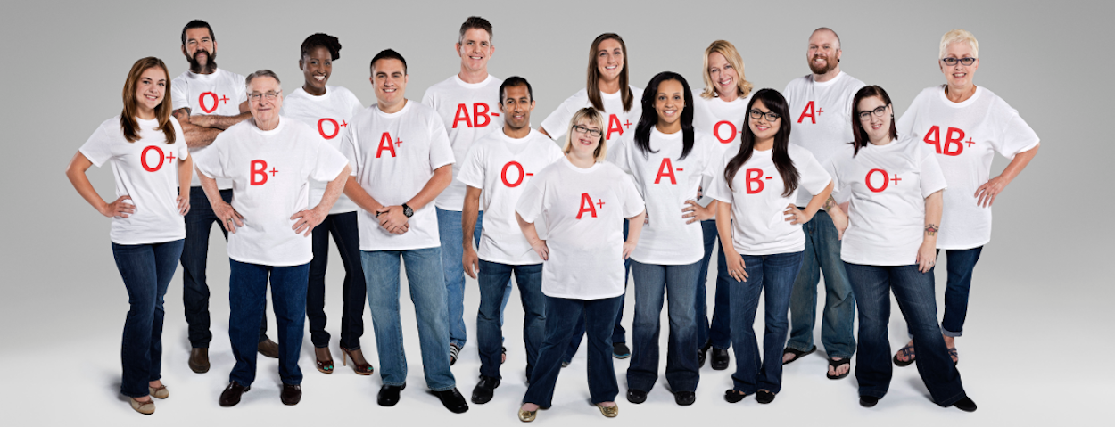 Group of individuals standing with blood type choices on white t-shirts