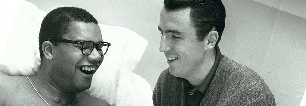 Jack Twyman at the hospital bed of Maurice Stokes who is smiling.