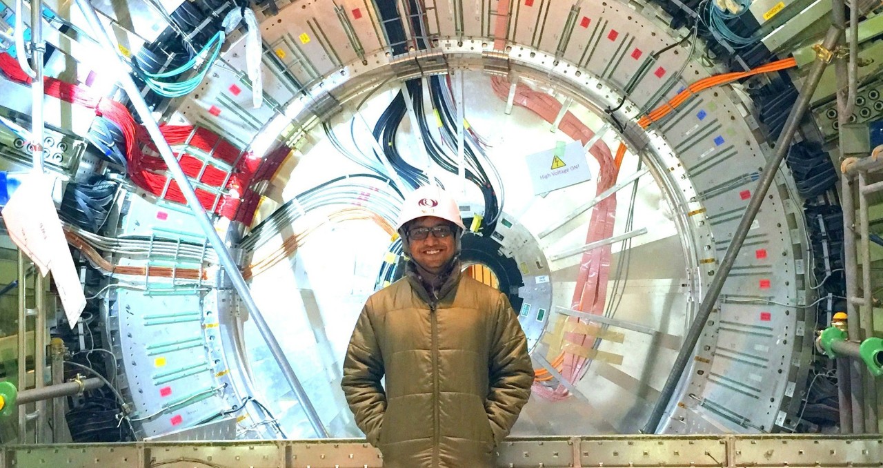 UC postdoctoral fellow Saurabh Sandilya stands in front of the Belle II detector in Japan's SuperKEKB collider.