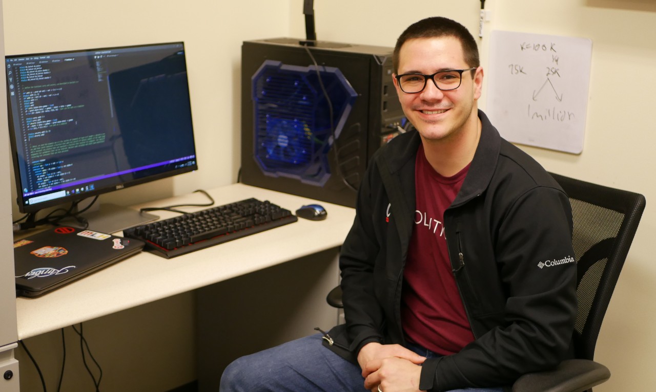 Mace sitting at desk in computer lab