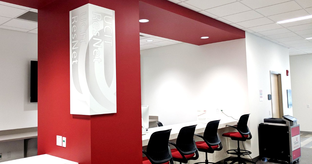 A row of chairs lines a white desk; a sign reading "ResNet" hangs on a red wall