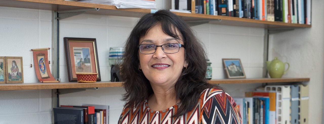 Woman stands in front of bookshelf