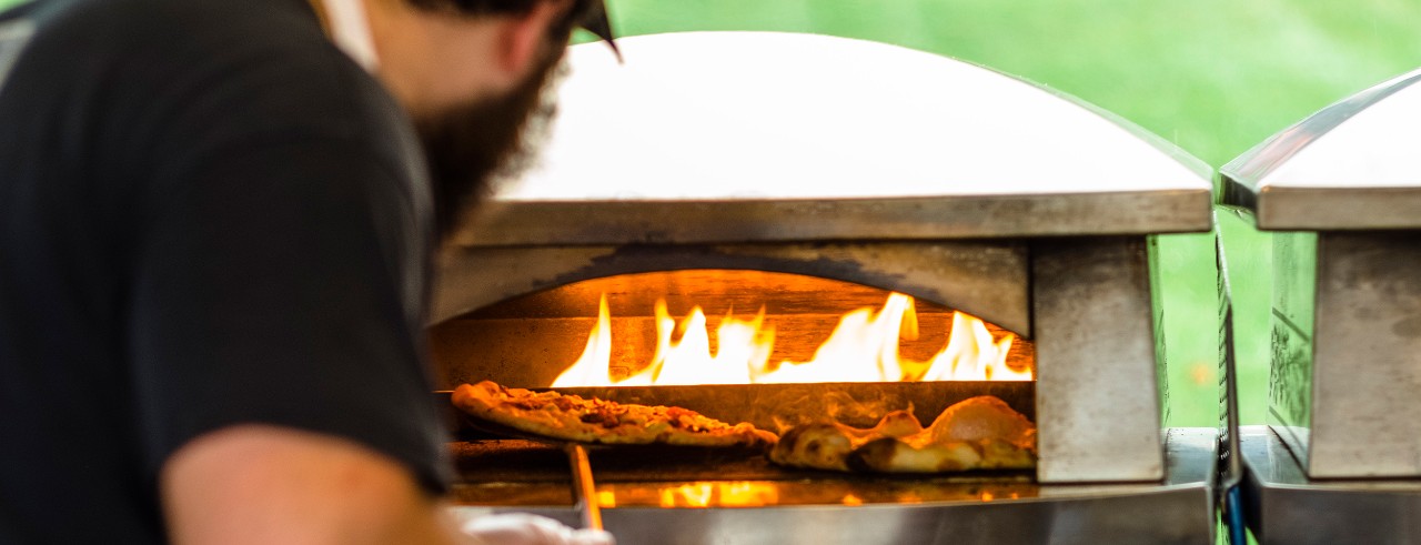 Man putting pizza in oven