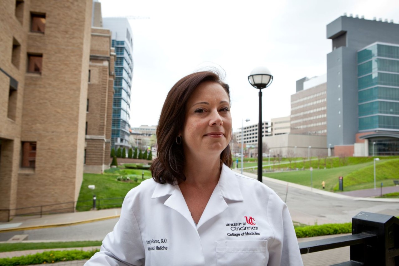 Dr. Emily DeFranco in white coat standing outside on the UC medical campus