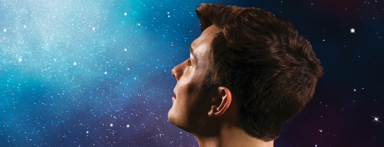 A boy looks up at the night sky