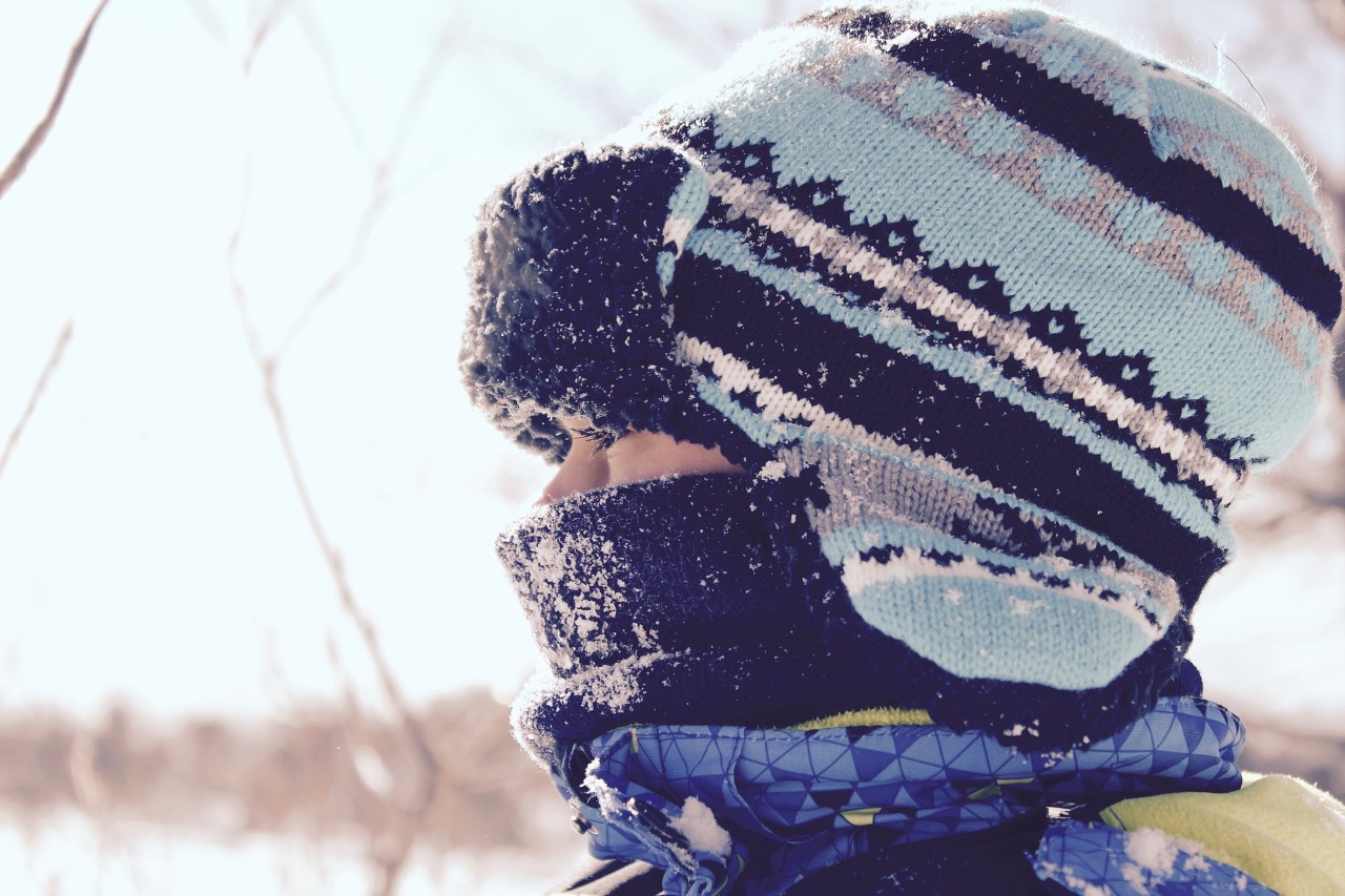 Little girl wearing a blue hat in the snow
