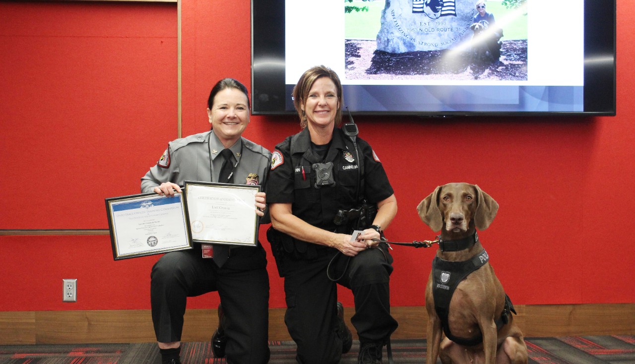 UCPD Chief Maris Herold poses with Officer Lori Cronin and K9 Harley.