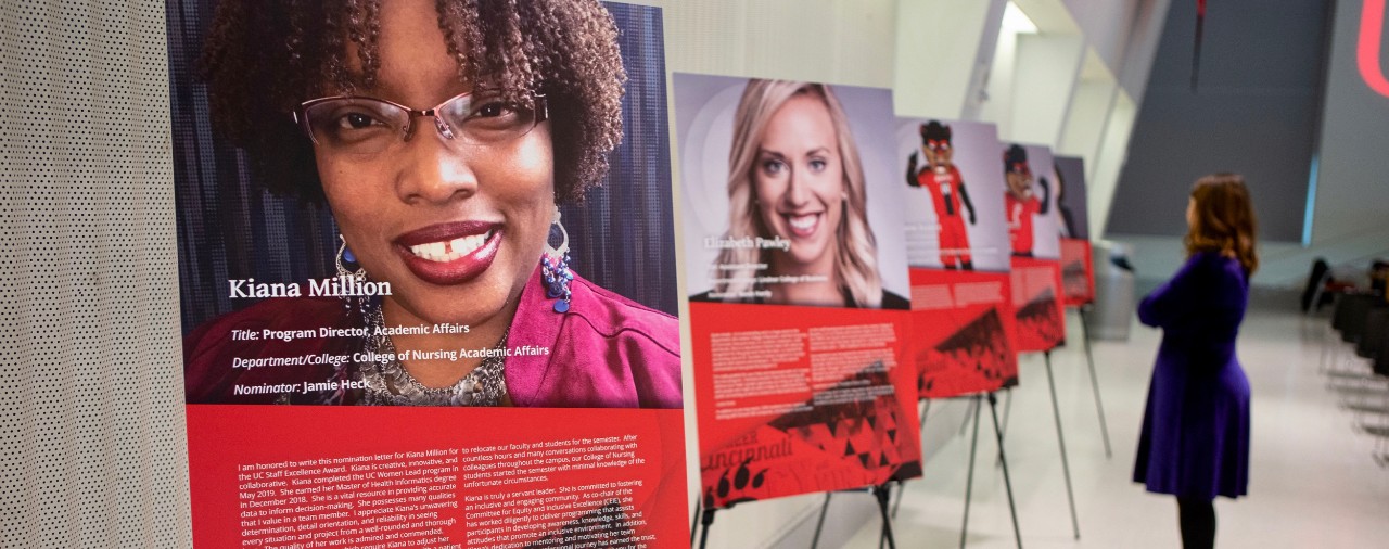 Long hallway line with posters of UC 2019 Staff Excellence Award winners.