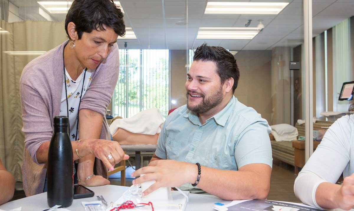 Eva Fried, Program Director for the online Master of Science in Nurse Midwifery, works with a student during an on-campus intensive.