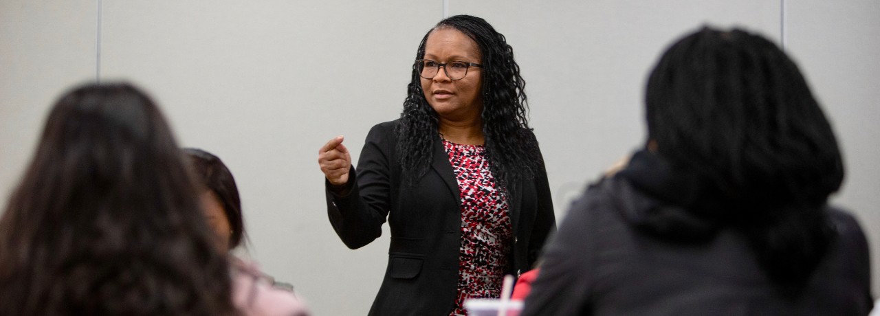 Dy'an Marinos, assistant director of UC DEI, talks in front of a class