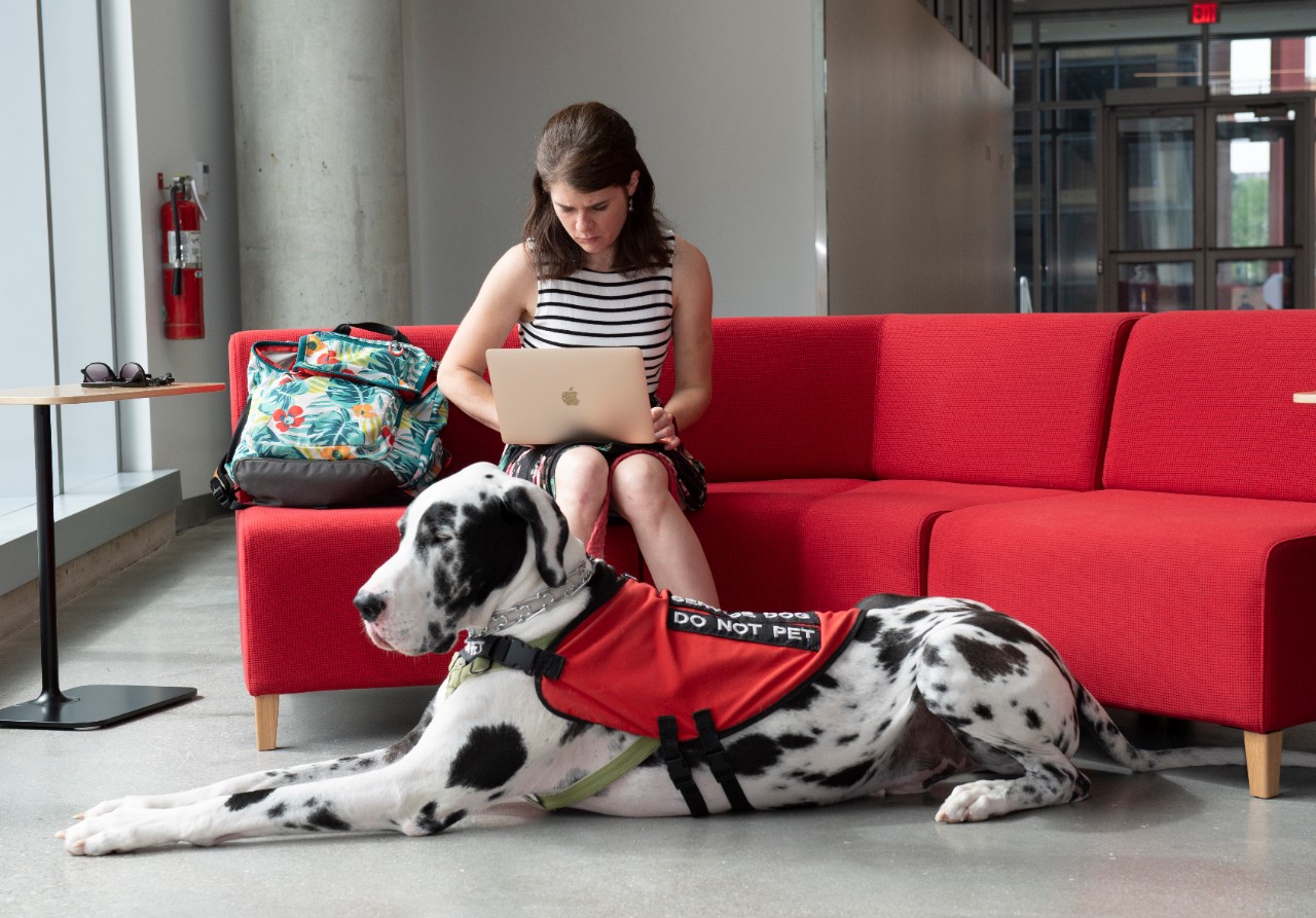 Caroline Spencer, CAHS student, with her Great Dane dog, Clark, in front of the new Allied Health Sciences building.