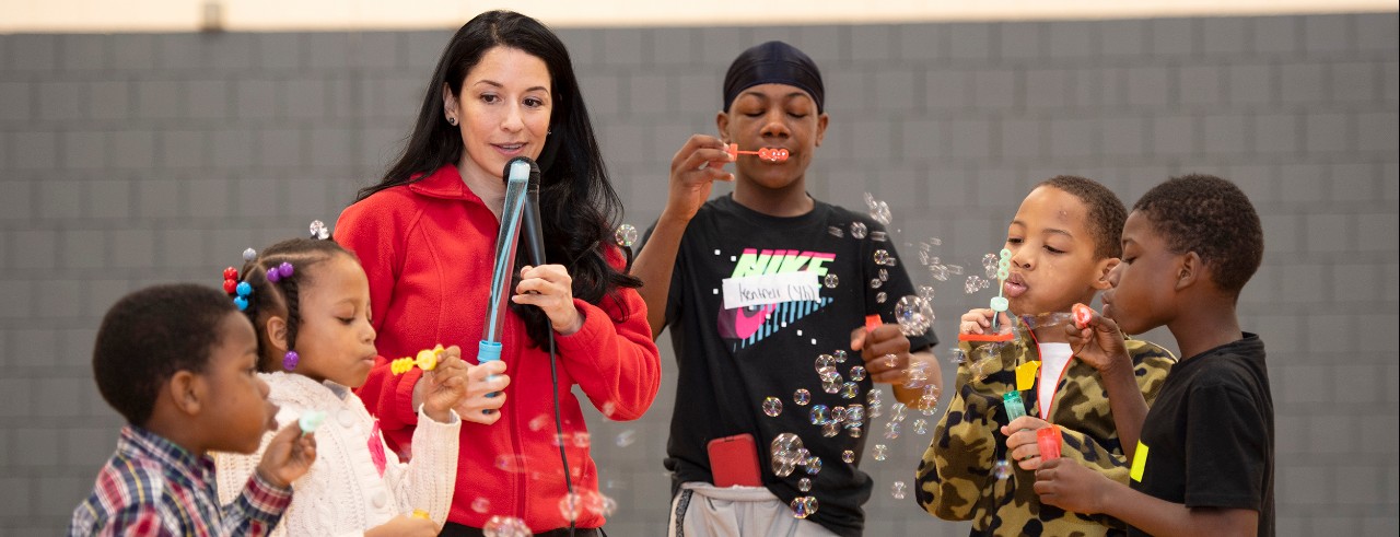 Maria Espinola seen with children blowing bubbles.